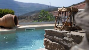 Una piscina con un borde de piedra y un farol envuelto en cuerda.