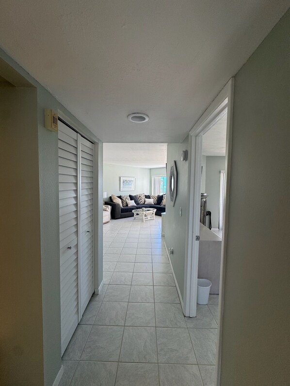 A hallway leading to a living room with a sofa and a coffee table.