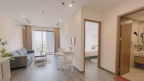 A modern apartment with a living room, dining area, and bedroom. It features a large window, a balcony, and a view of the city. - 1BR 12FL-Vinhomes Ocean Park Ha Noi (Hanoi)