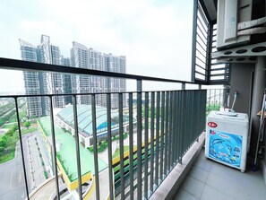 A balcony with a view of high-rise buildings, a green sports field, and a water fountain. - 1BR 12FL-Vinhomes Ocean Park Ha Noi (Hanoi)