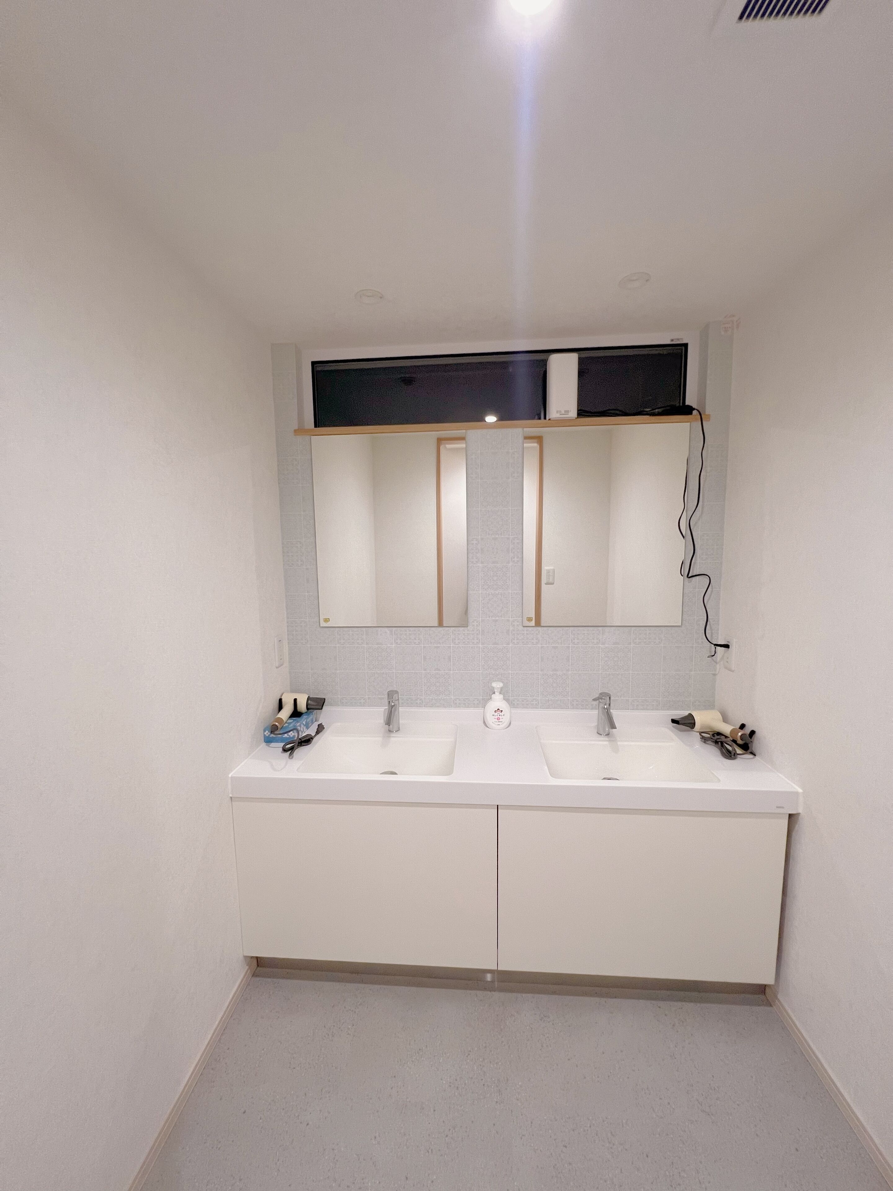 Une salle de bain avec deux lavabos, un miroir et un porte-serviettes.