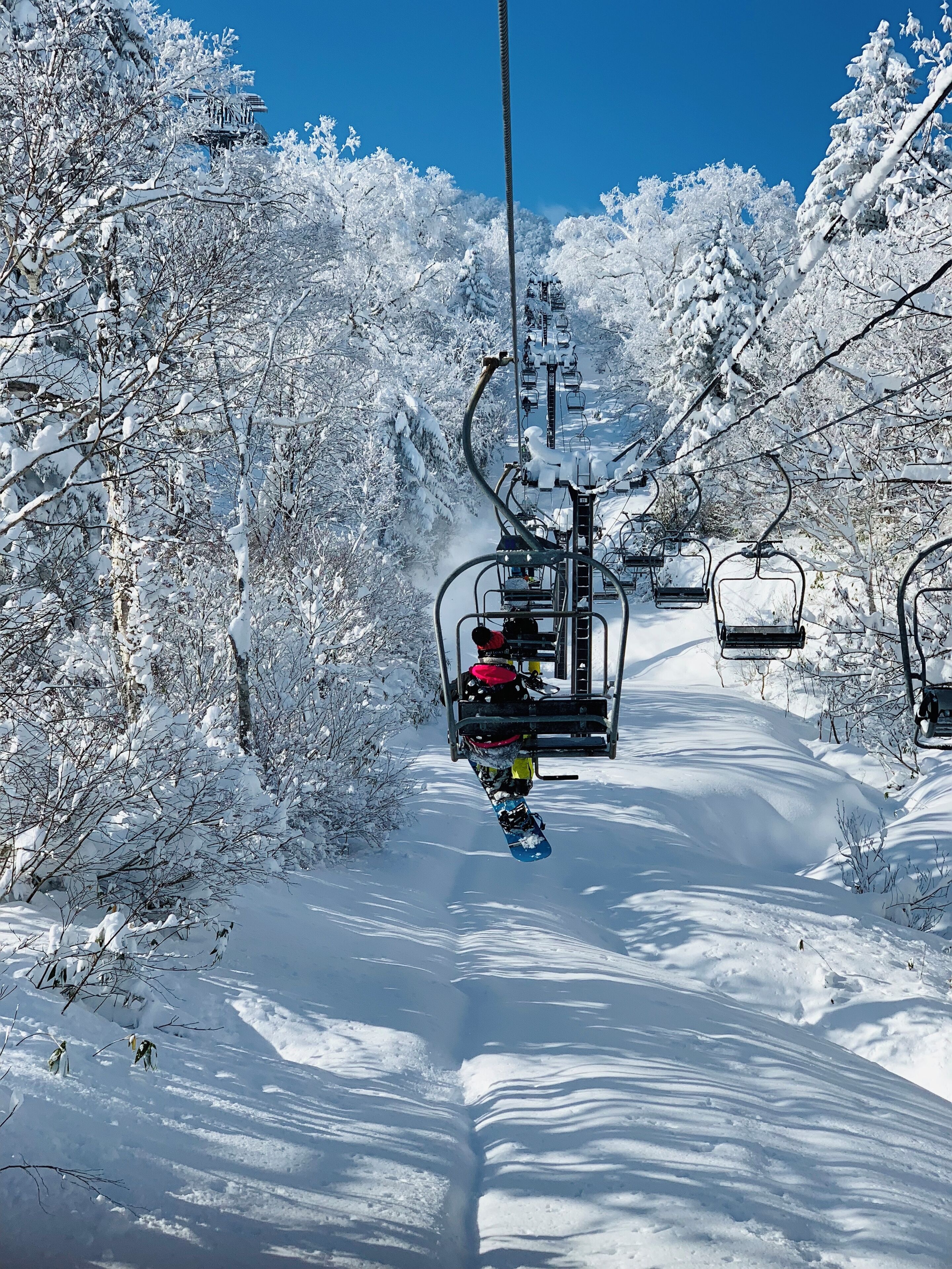 Un telesilla transportando a un snowboarder.