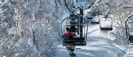 Un telesilla transportando a un snowboarder.