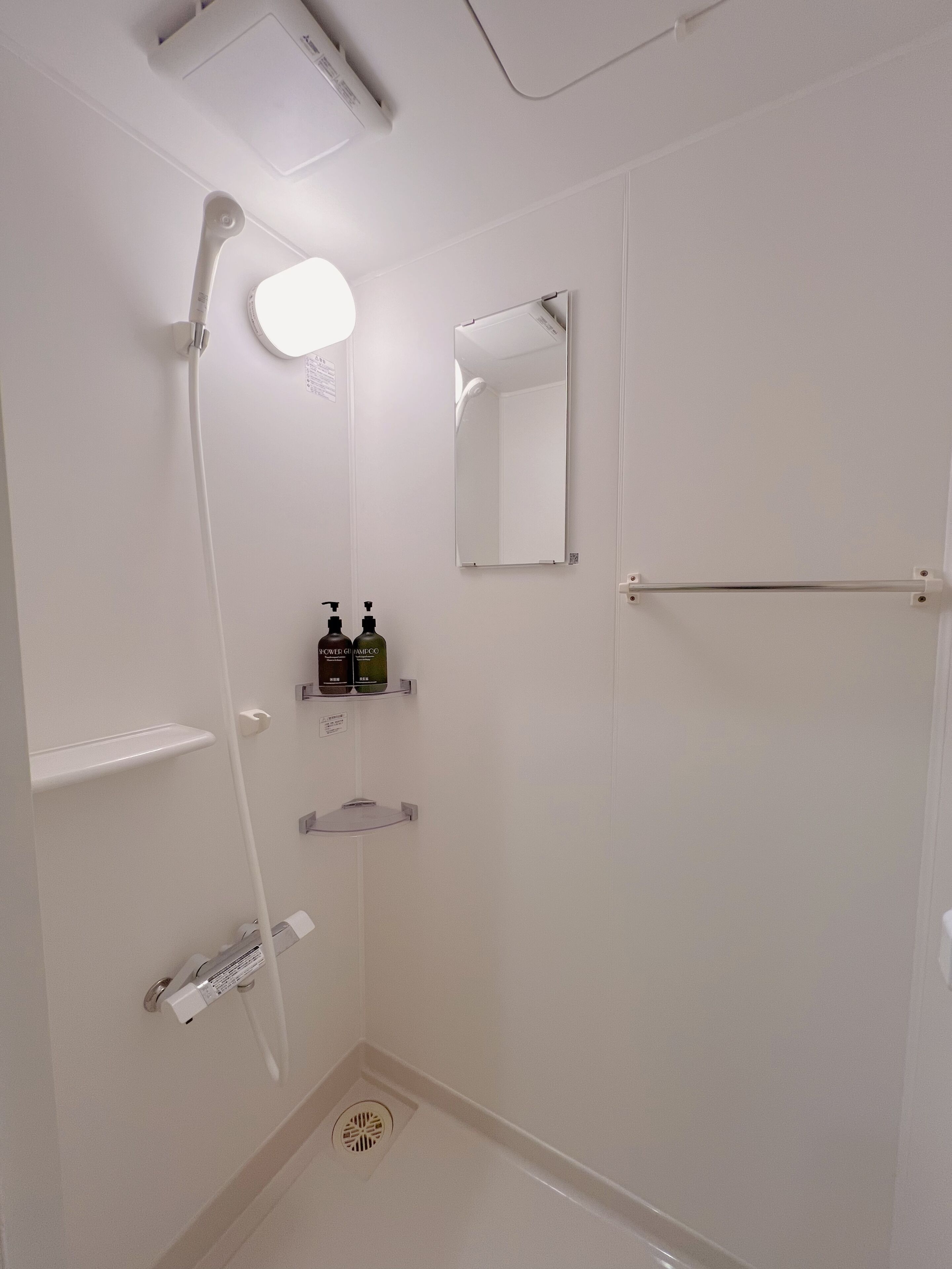Une salle de bain moderne équipée d’une douche, de toilettes, d’un lavabo et d’un miroir.