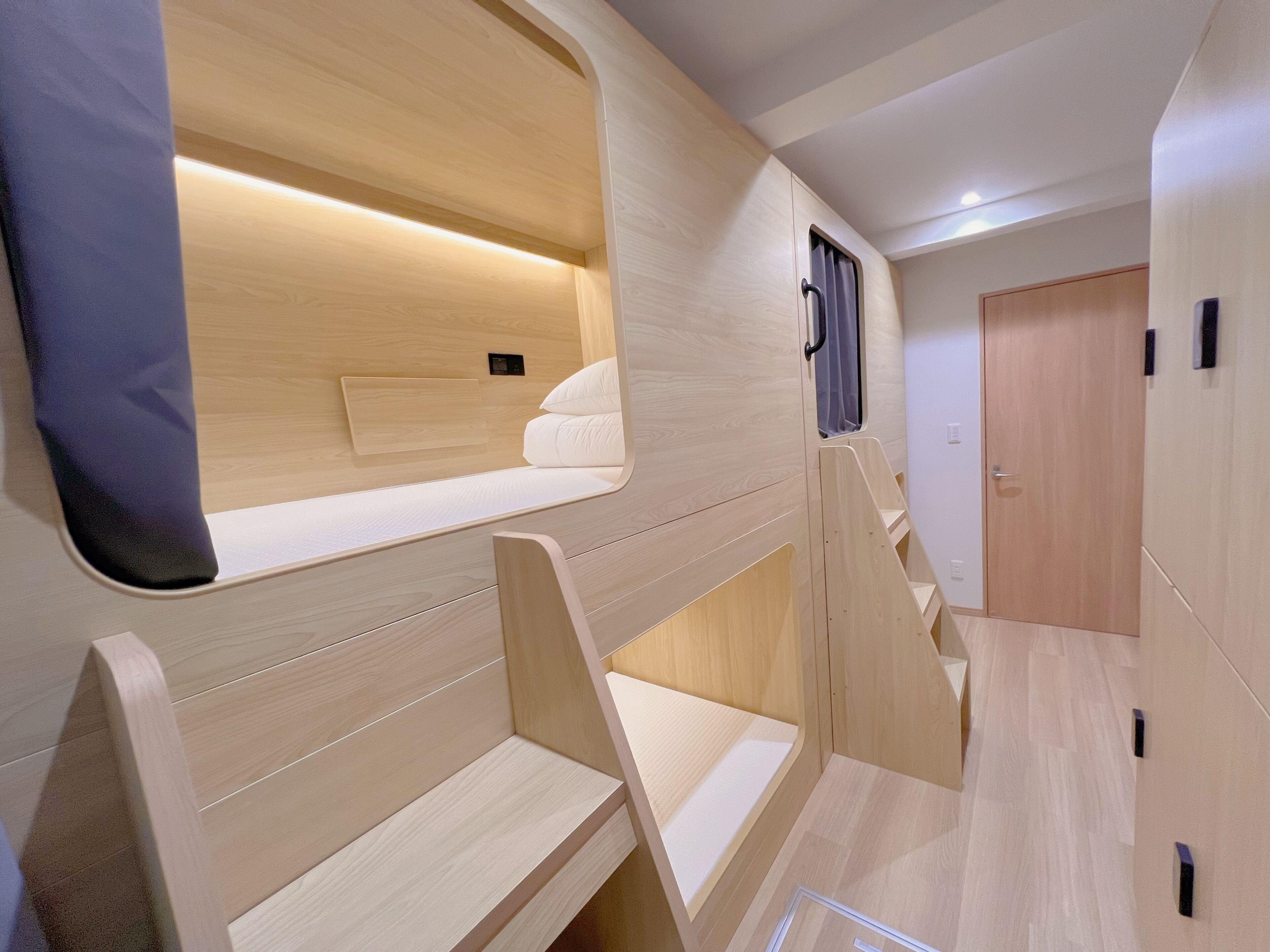A modern interior with a bunk bed, wooden walls, and a small window.