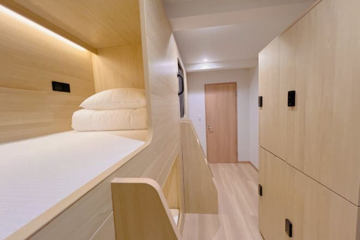 Una habitación moderna y funcional con literas, armarios empotrados y una puerta pequeña.
