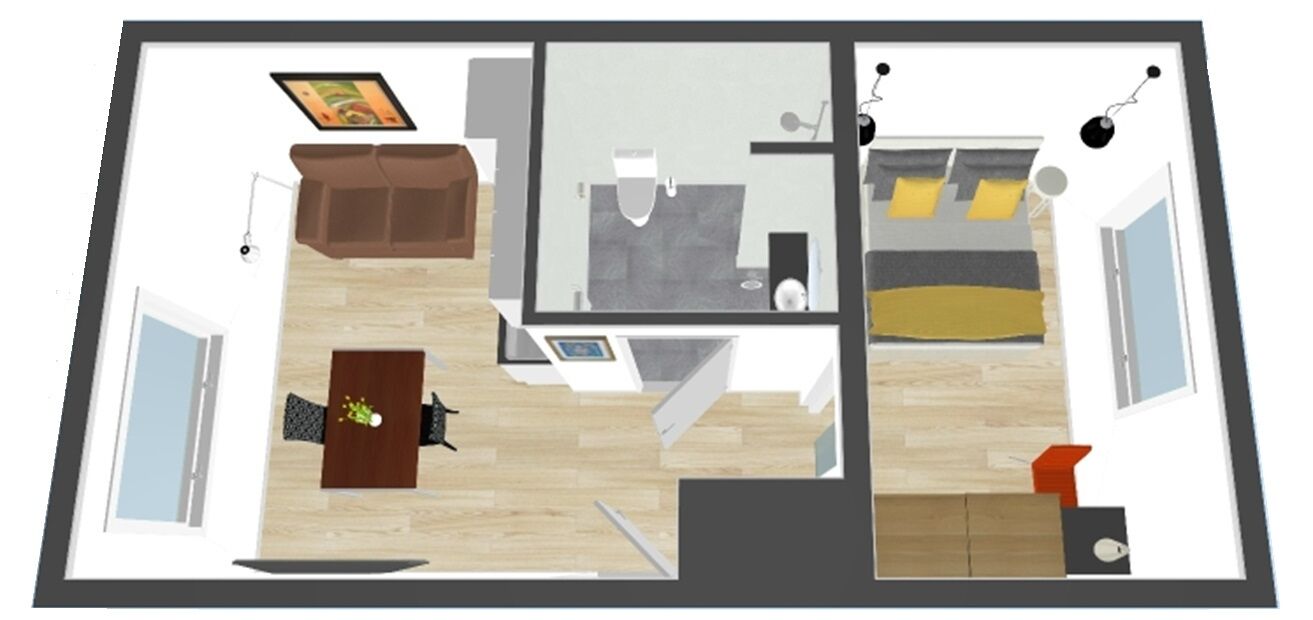 Un plan d’étage d’une chambre d’hôtel comprenant un lit, un bureau, une chaise, un canapé et une salle de bain.