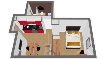 A 2-bedroom apartment layout with a kitchen, dining area, and a separate bedroom with a bed and nightstand.