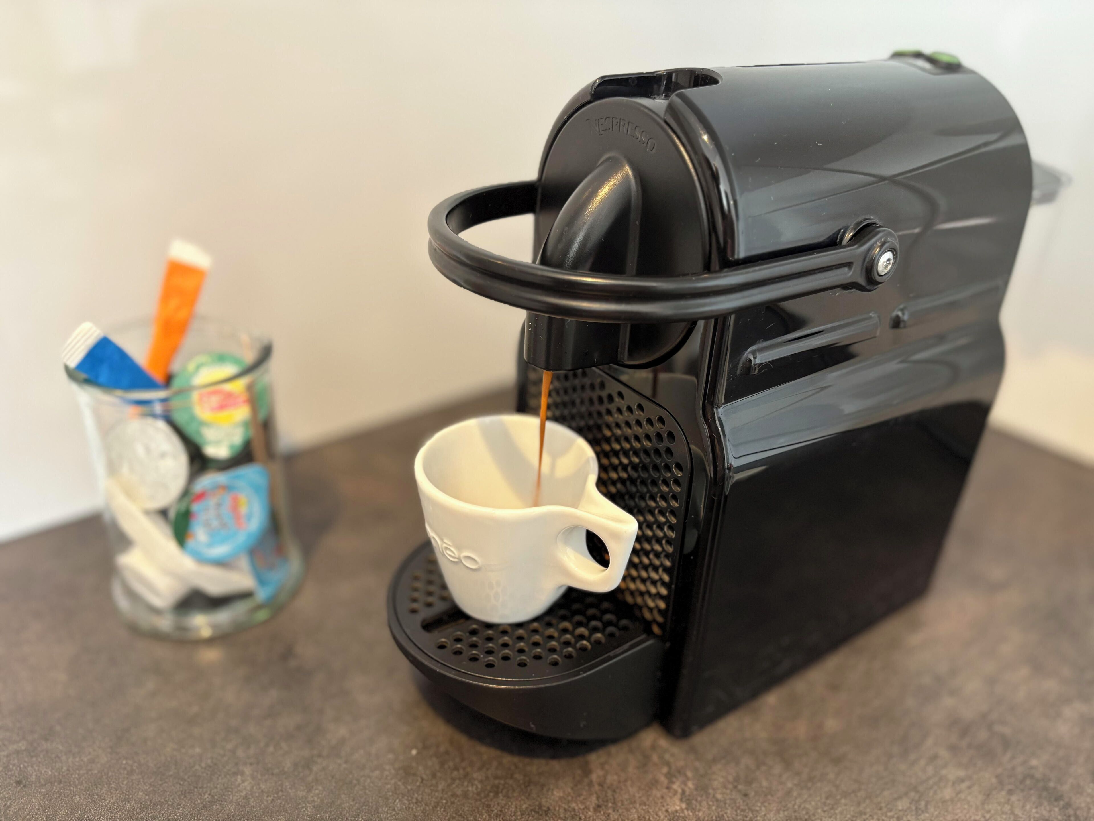 A coffee machine dispensing coffee into a cup.