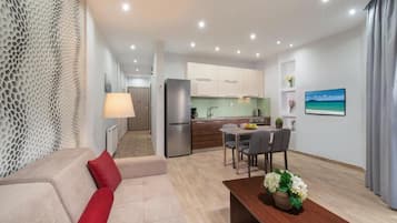 Apartamento Deluxe, vistas a la ciudad | Zona de estar | Televisión de pantalla plana de 30 pulgadas con canales digitales