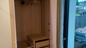 Een houten kast met open deuren, met planken en ruimte om kleding op te hangen.