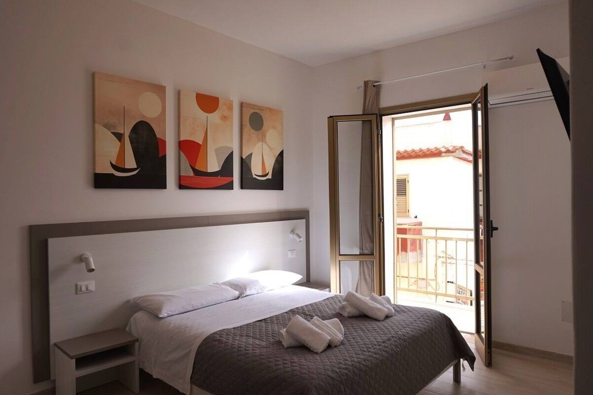 Ein modernes Hotelzimmer mit einem Bett, Nachttischen und Kunstwerken an der Wand.