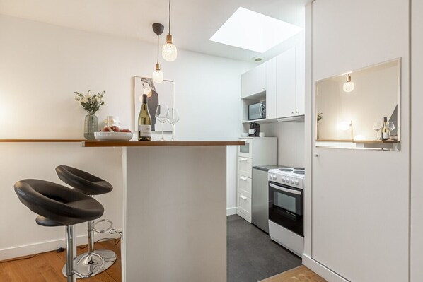 Een koelkast, een microgolfoven, een oven, kookgerei, borden en bestek