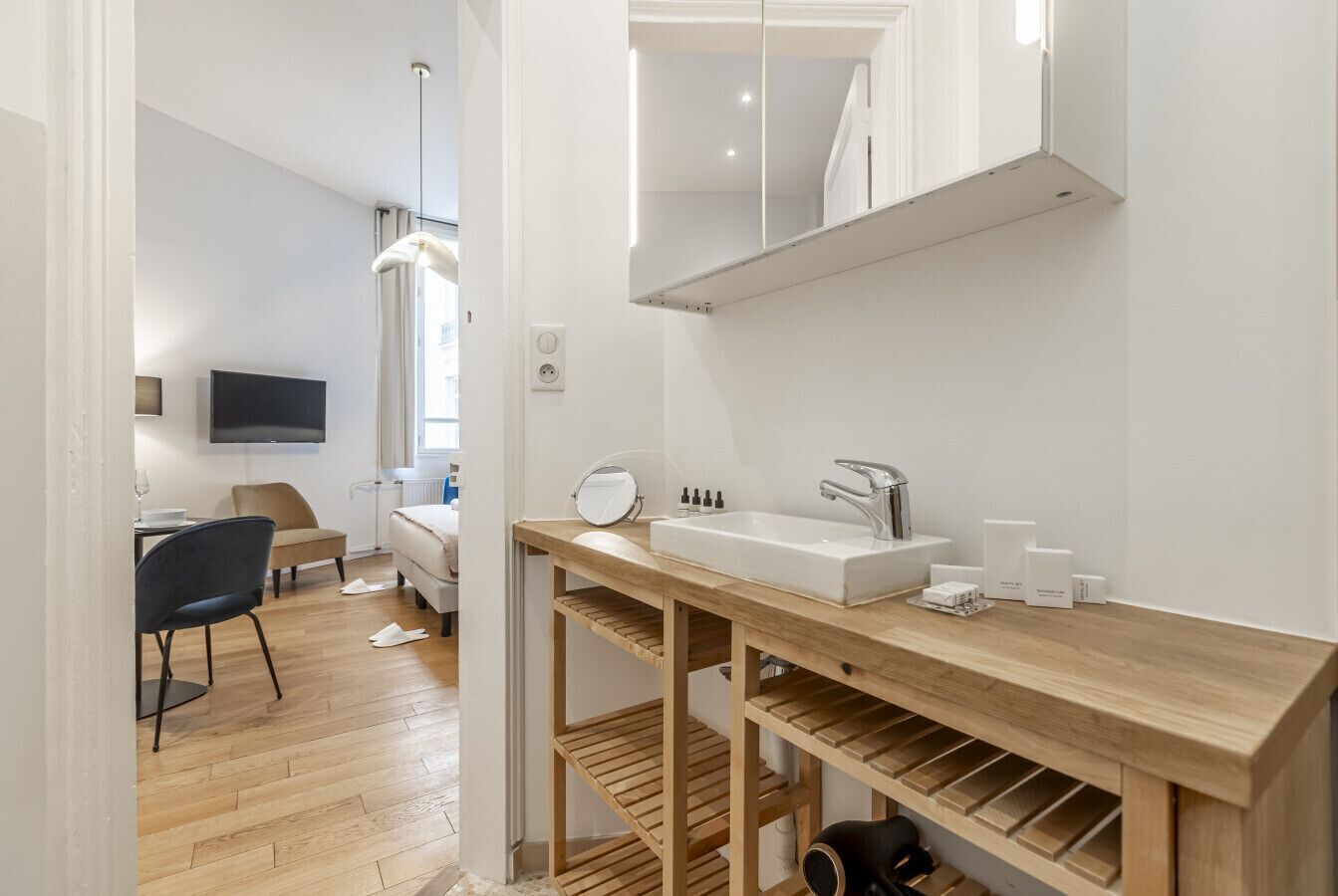 Un bagno moderno con un mobile vanitario in legno, uno specchio e un lavabo.