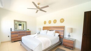 A bedroom with a bed, nightstands, a dresser, a ceiling fan, and decorative wall art. - Casa Bella with private swimming pool (Aguada)