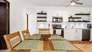 A modern kitchen with white cabinets, a microwave, oven, and dishwasher. - Casa Bella with private swimming pool (Aguada)