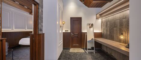 A modern interior with a wooden ceiling, a stone wall, and a long counter with a light fixture.
