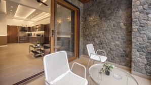 Μια σύγχρονη κουζίνα με ξύλινα ντουλάπια και έναν τοίχο με πέτρινη επένδυση που λειτουργεί ως διακοσμητικό στοιχείο.