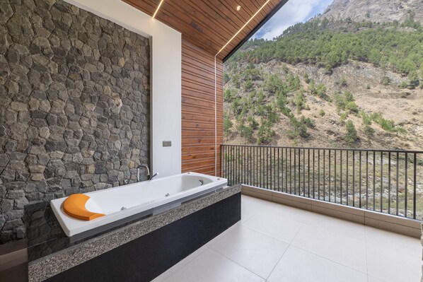 A modern bathroom with a stone wall, a wooden ceiling, and a view of a mountainous landscape. - Echor Noah Villa Tirthan Valley (Banjar)