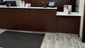 Un comptoir d’accueil avec un mur revêtu de panneaux en bois, une décoration en forme de croissant de lune et un tapis noir.
