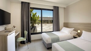 A hotel room with two beds, a desk, a chair, a TV, and a large window with curtains. - SIMON HOTEL APRILIA (Aprilia)