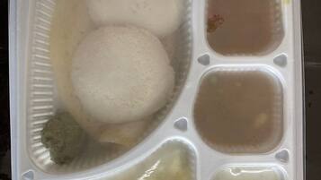 A plastic container with compartments containing food items.