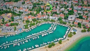 An aerial view of a coastal town with a marina, residential buildings, and a beach. - Studio+free parking, 100m to sea (Crikvenica)