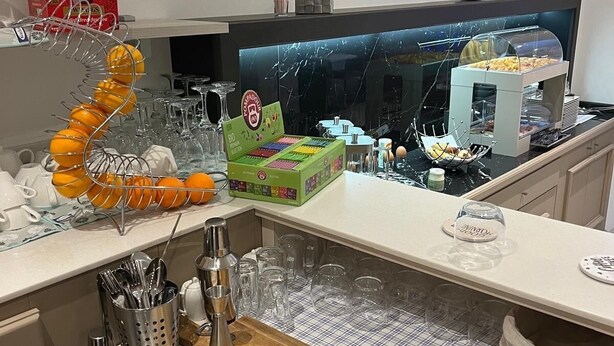 Une cuisine moderne dotée d’un plan de travail en marbre, d’une planche à découper en bois et d’une vitrine en verre.