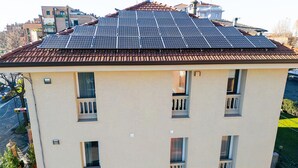 Un bâtiment doté d’un toit plat recouvert de panneaux solaires, de nombreuses fenêtres et d’une façade de couleur beige.