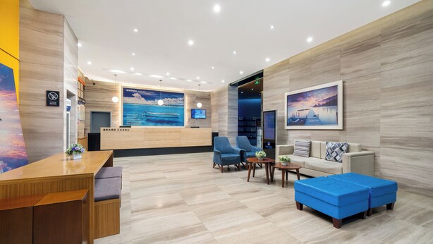 A modern lobby with a reception desk, seating area, and artwork on the walls. - Stay at Guilin Downtown (Guilin)