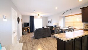 A modern apartment with a living room, dining area, and kitchen. - Condo next door to SDC (Branson)