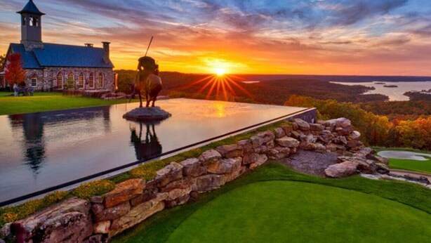 A serene landscape with a stone building, a pond, and a sunset. - Condo next door to SDC (Branson)