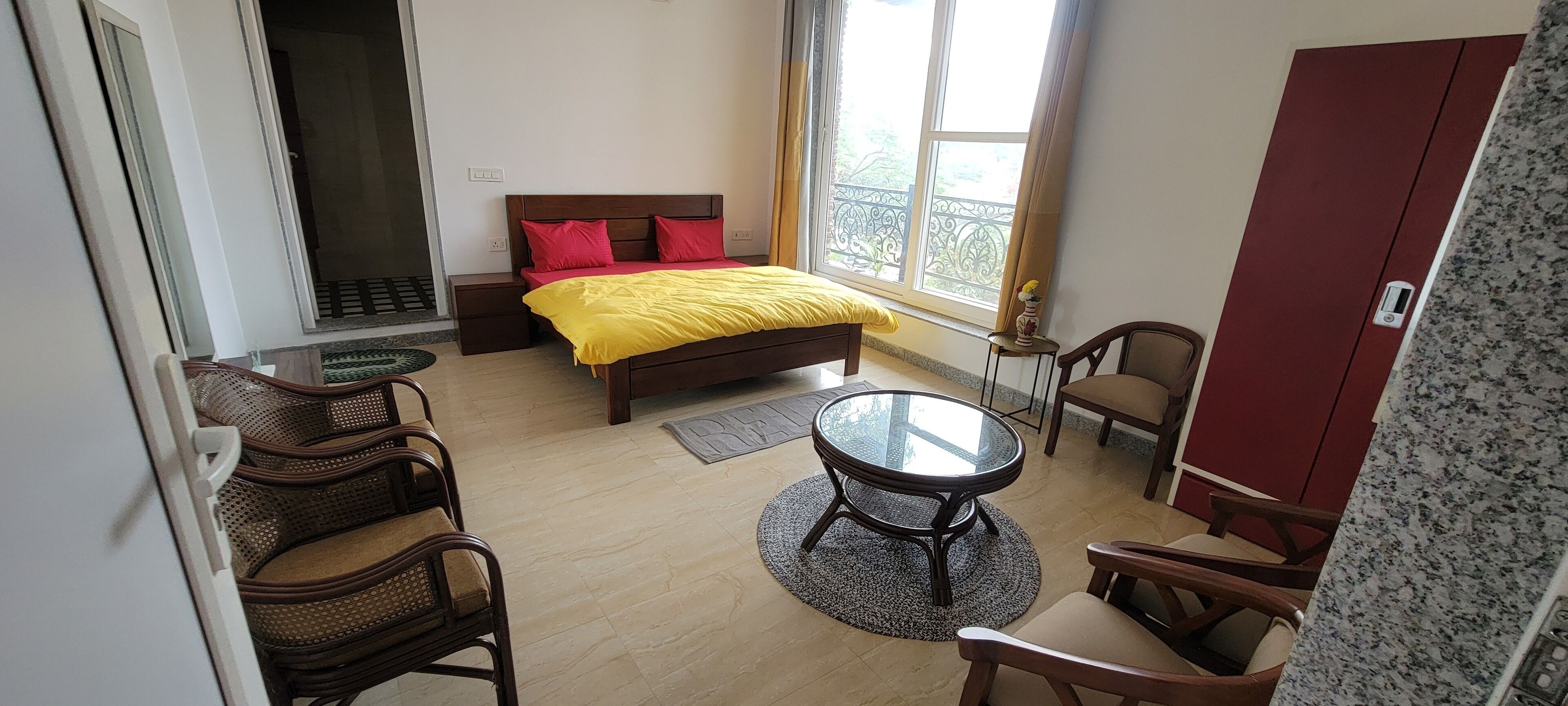 A hotel room with a bed, a round table, and two chairs.