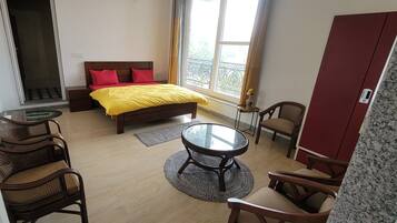 A hotel room with a bed, a round table, and two chairs.