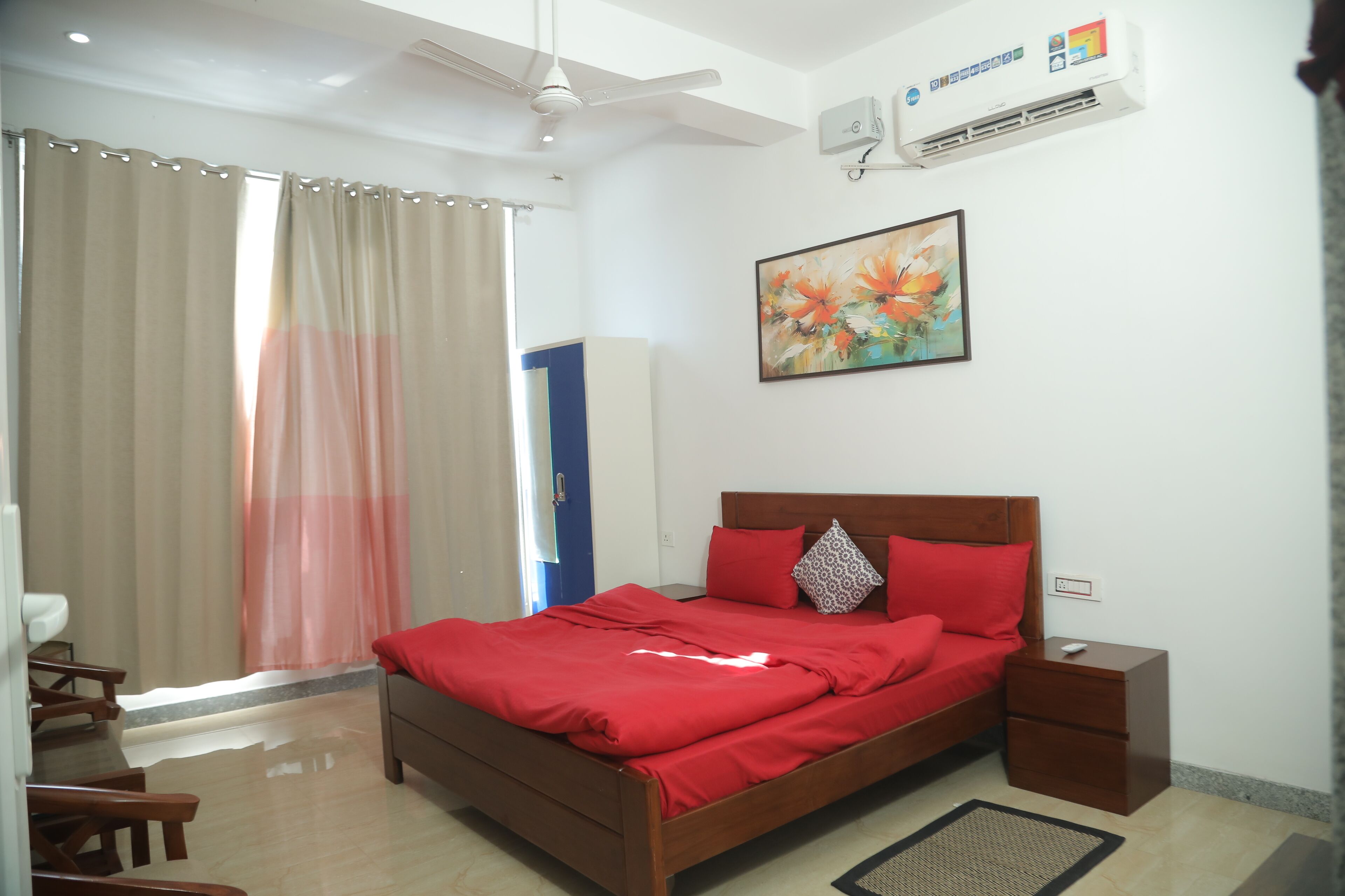 A bedroom with a bed, bedside table, and a ceiling fan.