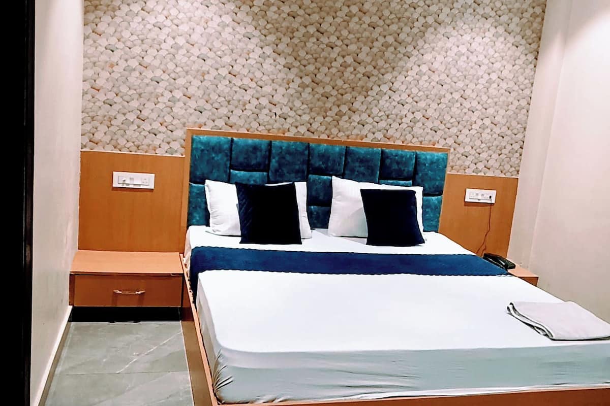 A bedroom with a bed, a ceiling fan, a textured wall, and a tiled floor.
