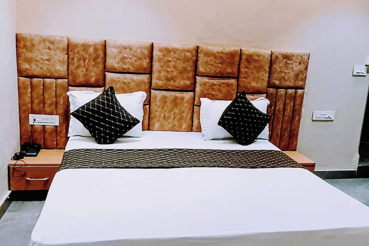 A neatly made bed with a headboard, a bedside table, and a nightstand.
