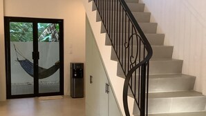 Un interior moderno con una escalera, una hamaca y un dispensador de agua.