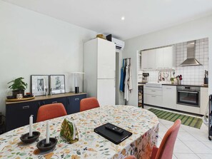 A modern kitchen with white cabinets, a stove, and a microwave.