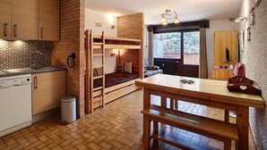 A compact kitchen with wooden cabinets, a built-in bench, and a view of the outdoors. - Studio La Clusaz for 4 people, Pets allowed, 32 m² (La Clusaz)