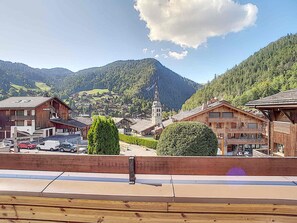 A mountain village with wooden buildings, a church, and a clear view of the surrounding hills.