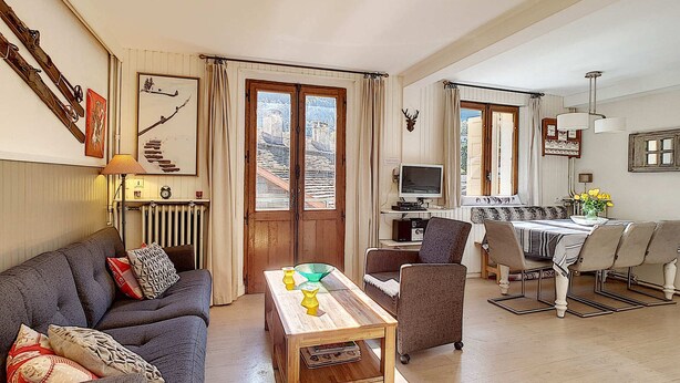 Un salon comprenant un canapé, une table basse et un coin repas avec une table et des chaises.