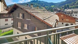 Il s’agit d’un bâtiment traditionnel en bois, doté d’un toit en pente, d’un balcon et offrant une vue sur un paysage montagneux.