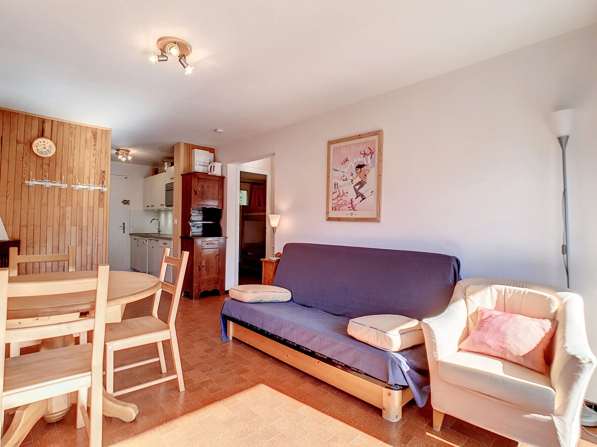 A compact living space with a dining area, kitchenette, and a sofa.