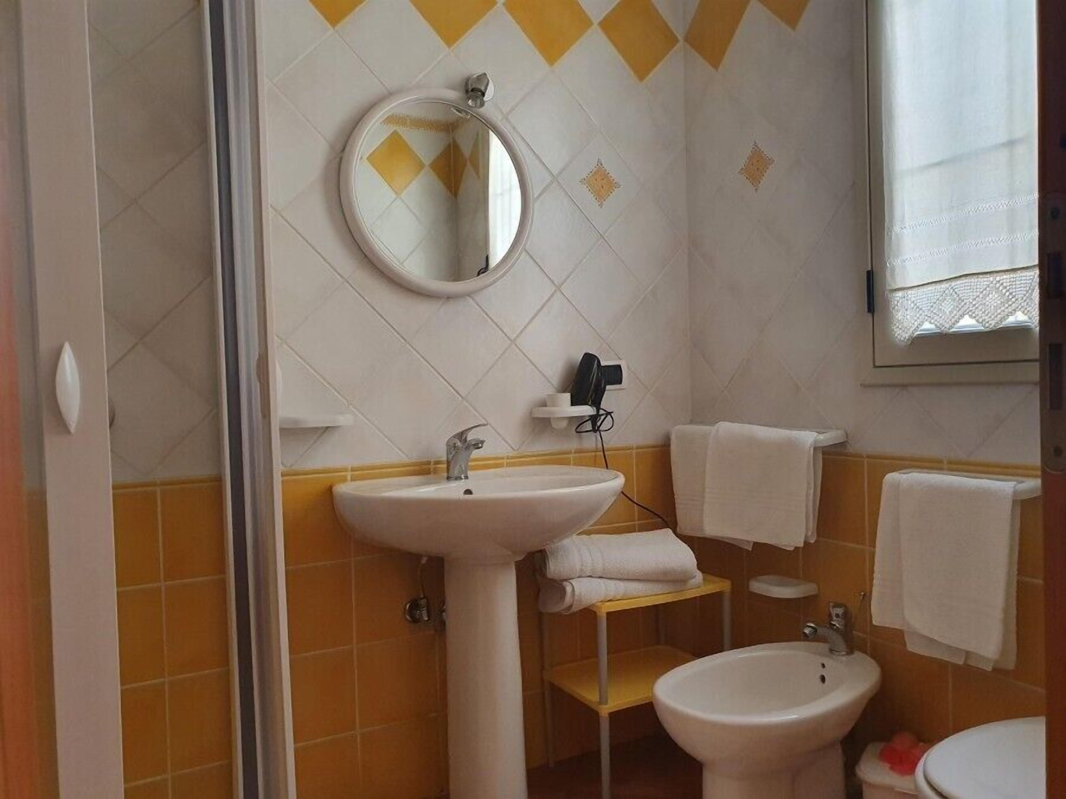 Casa de banho com duas pias, um espelho e uma janela.