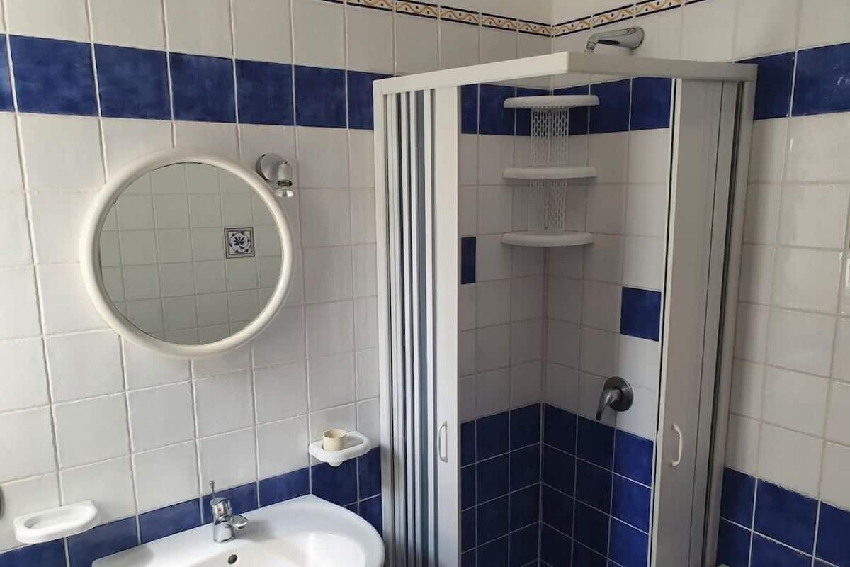 Ein Badezimmer mit Waschbecken, Spiegel und Dusche.