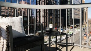 A balcony with a black metal table, a white pillow, and a bottle of wine. - National Landing Spot Near Metro Sleeps 7 (Arlington)