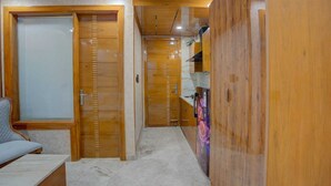 Ein Korridor mit Holztüren, einer Bank und einem Kühlschrank.