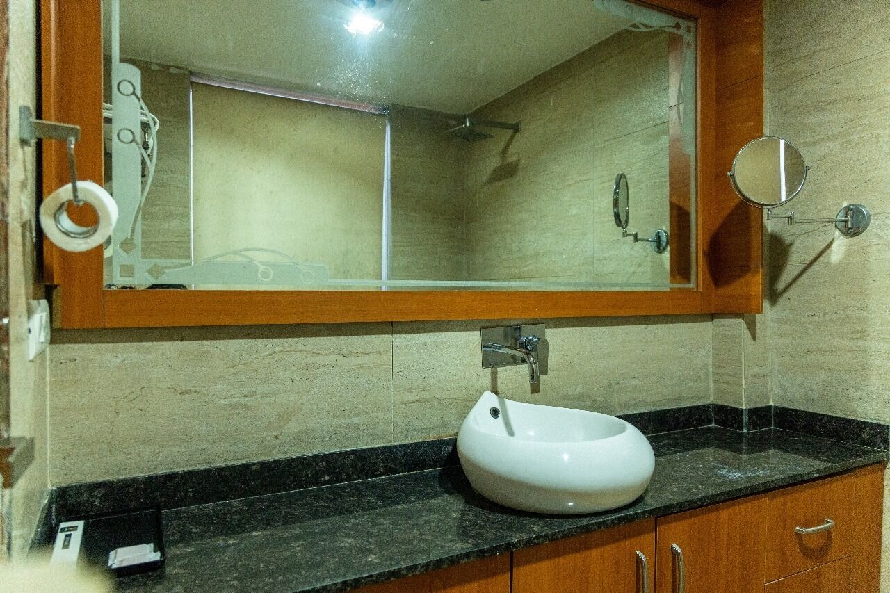 A bathroom with a white sink, a mirror, and a shower.