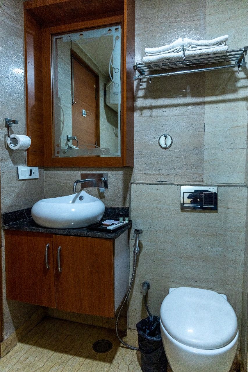 Un baño con lavabo, espejo, toallero, inodoro y ducha.